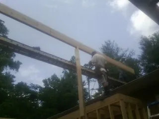 Carpenter setting a ridge beam over a new addition frame — Ice Dam Removal by Roofing Brothers in Falls Village