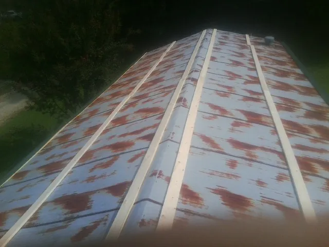Rusted metal roof panels with new wood purlins before replacement — Storm Damage Roof Repair in Falls Village by Roofing Brothers