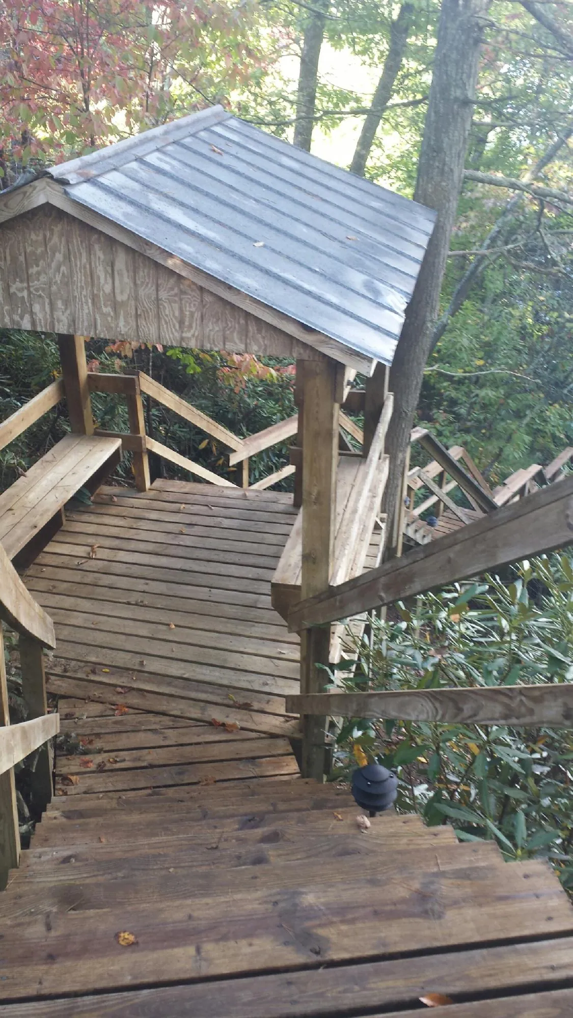 Metal roofed shelter over wooden steps on a wooded walkway — Skylight Repair & Installation work by our crew in Falls Village