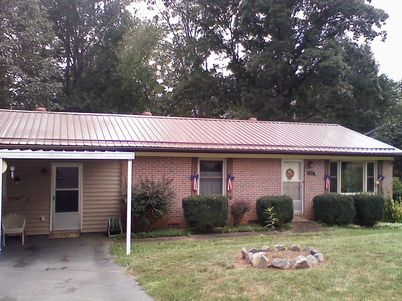 Bronze metal roof and carport on a brick ranch home — Roof Repair work by our crew in Falls Village